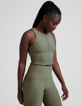 side image of a green racerback cropped tank with a half zip up detail in front.